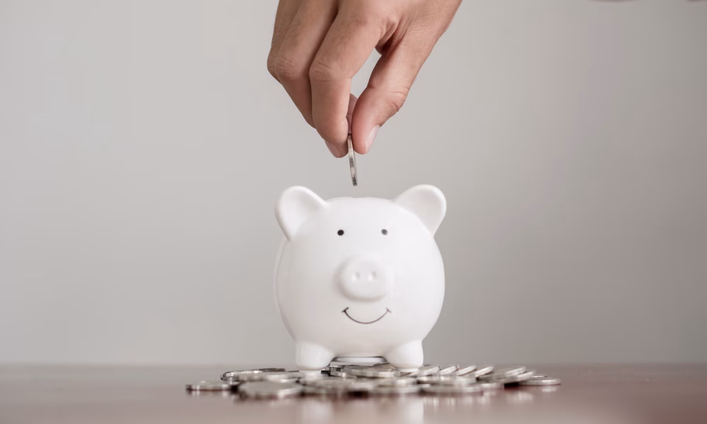 The hand of a businessman puts coins in a piggy bank, saves money with coins, steps into a successful growth business, and saves for retirement concept.